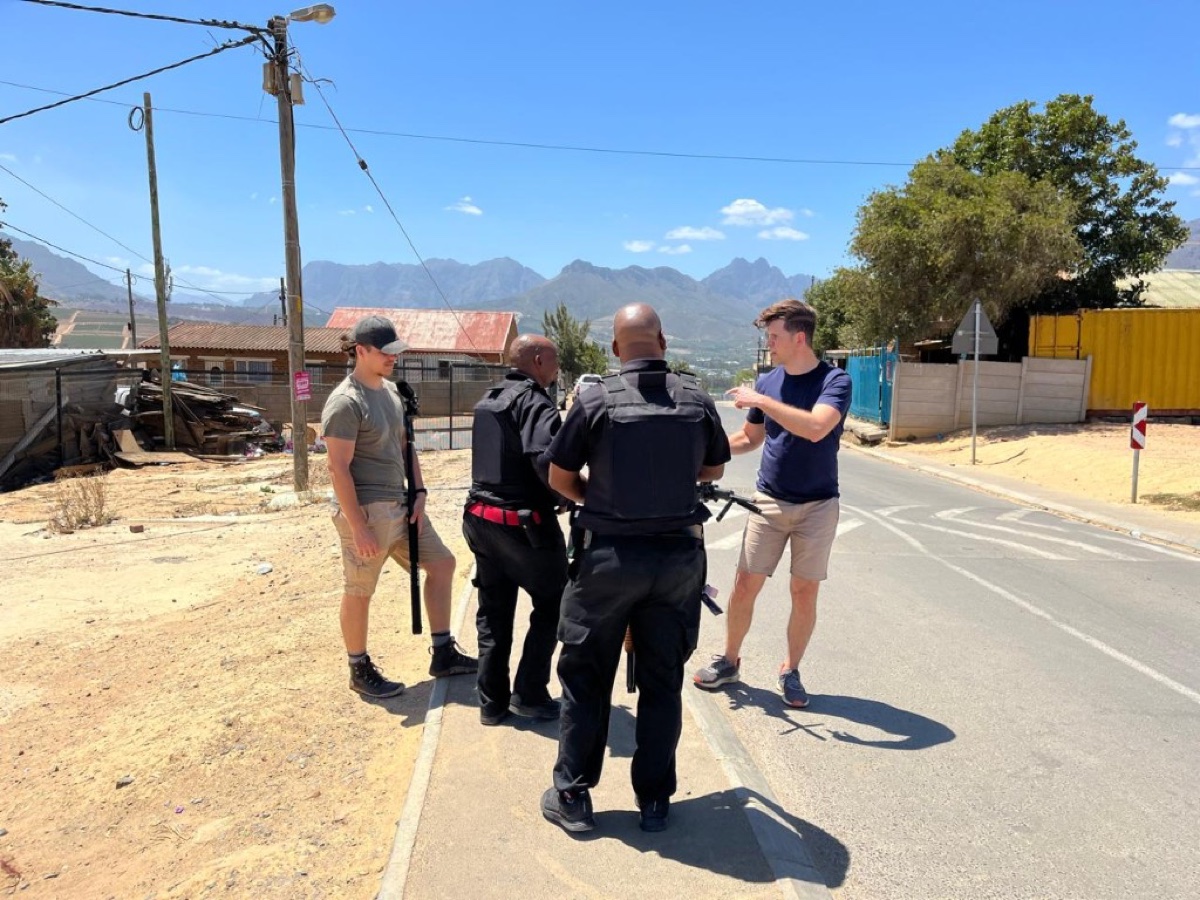 Programme leads and PSIRA-registered officers planning a patrol route on a Kayamandi street.